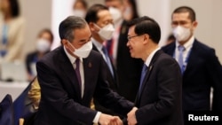 香港特首李家超2022年11月18日在出席亚太经合组织峰会期间与中国外长王毅握手。(路透社)