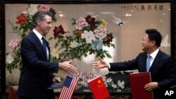 美国加州州长纽森(左)在北京访问期间与中国国家发改委主任郑栅洁签署备忘录。(2023年10月25日)