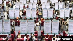 资料照片:中国安徽省大学毕业生在合肥市举行的一个招聘会上寻找工作。(2023年9月4日)