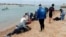 FILE - Para migran diselamatkan oleh penduduk setempat di tepi pantai, dekat kota barat daya Cádiz, Spanyol, 30 November 2023. (AP/Jorge Gonzalez Casares)
