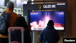 资料照片:2023年3月16日,人们在韩国首尔的一个火车站观看电视新闻中播放有关朝鲜向其东海岸海域发射弹道导弹的报道。(路透社照片)