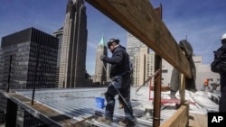 资料照片:2023年4月11日,建筑工人在纽约曼哈顿金融区的一座高层建筑上安装屋顶。(美联社照片)