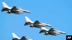 资料照片:2023年8月15日,美国制造的F-16战斗机在波兰首都上空飞行,参加庆祝波兰建军节的大规模阅兵式。(美联社照片)
