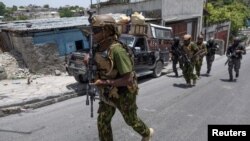 Inite SWAT Polis Nasyonal Ayiti, PNH ak polisye Kenyan yo grenpe yon morn pou monte nan yon blende pandan yo tap fe patwouy nan yon katye nan Potoprens, 28 Jyen 2024.