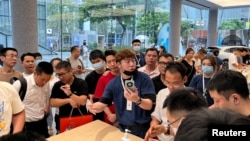 深圳一家华为商店的店员在向人们展示Mate 60系列手机。(2023年8月30日)