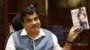 Menteri Transportasi dan Perkapalan India Nitin Gadkari memamerkan buku yang ditulisnya di kantornya di New Delhi, India, 26 Agustus 2015. (Foto: REUTERS/Anindito Mukherjee)