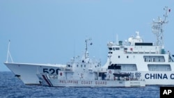 资料照片:2023年4月23日,一艘中国海警船在南中国海有争议海域拦截菲律宾的海岸警卫队巡逻船,险些造成撞船事故。(美联社照片)