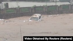 2024年4月23日,中国广东遭灾严重的江湾镇的一辆汽车被冲入洪水中。(照片为社媒视频截图)