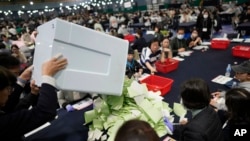 韩国首尔的选举官员准备点数一处投票站里为国会选举选民投出的选票。(2024年4月10日)