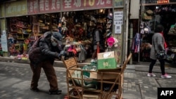 资料照:一名拾荒老人走过北京街头。(2021年3月5日)