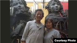 中国艺术家严正学(左)在其雕塑作品前拍照(照片来自高瑜推特)