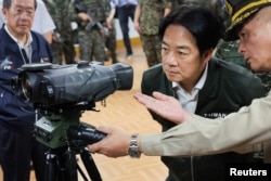 台湾总统赖清德在视察桃园军事基地时查看一架激光测距仪。(2024年5月23日)