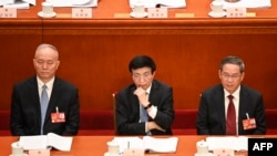 中共中央书记处书记蔡奇(左)、全国政协主席王沪宁(中)与国务院总理李强在中国人民大会堂出席全国人大会议。(2023年3月7日)