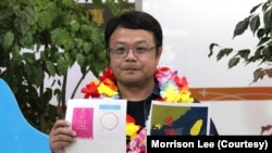 李孟居9月2日在台湾机场出示他四年前遭捕时,被中国海关视为谋反证据的小卡图样,包括为空服员打气的“爱与和平”小卡及“香港加油”小卡(美国之音特约记者李贤摄影)。