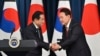 2023年5月7日,韩国总统尹锡悦和日本首相岸田文雄在首尔韩国总统办公楼举行双方会谈后召开的联合记者会上相互握手致意。