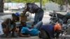 Orang-orang berlindung dari tembakan saat bentrokan antara polisi dan geng di kawasan Champs de Mars sebelah Istana Nasional di Port-au-Prince, Haiti, 8 April 2024.