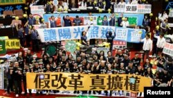 台湾立法院议员在台北的立法院议场内展示标语表达立场。(2024年5月28日)