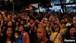 游客们在香港维多利亚港观看五一节的烟花。(2024年5月1日)