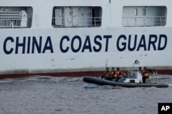 2023年4月23日,一艘中国海警船在南中国海有争议海域拦截菲律宾的海岸警卫队巡逻船,中国船员下到一艘马达船监视菲律宾海警船。