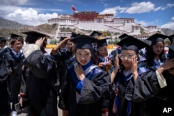 资料照片:2021年6月1日,政府组织外国记者参观期间,西藏大学的毕业生准备在拉萨布达拉宫广场上合影。