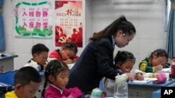资料照:中国当局组织媒体参观四川省甘孜州达巴县的香格里拉重点寄宿学校,一位老师在教一年级的学生写字母。(2023年9月5日)