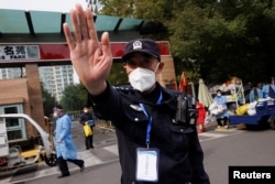 北京一居民区因疫情被封后保安禁止记者走近。(2022年10月20日)