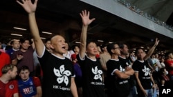 在香港举行的2022年卡塔尔世界杯和2023年亚足联亚洲杯预选赛第二轮香港对阵伊朗的比赛中,香港球迷身穿印有香港国旗黑色图案的T恤抗议政府。(2019年9月10日)