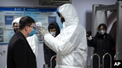 一名乘客星期天(1月26日)在北京地铁接受体温检测。