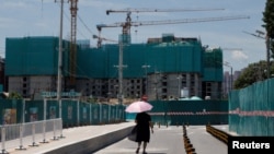 一名女子走过北京的一处住宅楼建筑工地。(2022年7月15日)