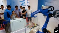 2017年8月23日,参展商在北京亦创国际会展中心的世界机器人大会上展示中国制造的工业机器人。(美联社照片)