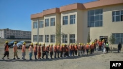 资料照:2021年10月24日,在阿富汗首都喀布尔南部的Dasht-e-Padula,阿富汗男子排队等候塔利班政府提出的一项解决饥饿的计划,该计划为数千人提供小麦,以换取劳动力。