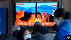 2022 年 2 月 27 日,在韩国首尔的首尔火车站播放的新闻节目中,人们在电视上观看显示朝鲜发射导弹的资料图像。(美联社)
