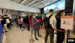 香港高铁西九龙总站售票大堂1月13日中午仍有大批旅客排队购票,车站指示牌显示等候时间约两小时 (美国之音/汤惠芸)