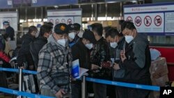 北京国际机场一个国际航班柜台排队的手持中国护照的乘客。(2022年12月29日)