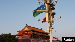 2019年10月7日,北京天安门广场,悬挂在灯柱上的中国和所罗门群岛两国国旗。 -资料图