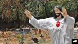 印度工人在新德里一处基督徒墓地里为埋葬新冠死者做准备。(2021年5月21日)