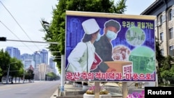 朝鲜平壤空荡荡的街道和路旁竖立的新冠防疫宣传画。(2022年5月23日)