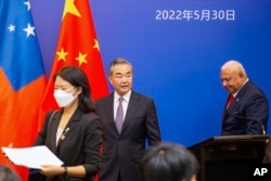 中国国务委员兼外长王毅与斐济总理巴依尼马拉马(右)在斐济出席太平洋岛国外长会议。(2022年5月30日)
