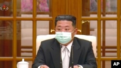 朝鲜领导人金正恩5月12日戴着口罩出席一次会议,承认爆发新冠病毒疫情。(电视画面截图)