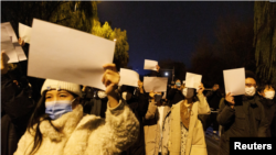 北京民众手举白纸上街游行,抗议中国严厉的防疫政策。 (2022年11月27日) ( Reuters)
