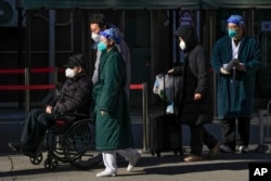 北京一家医院外一位坐轮椅排队离开发热门诊的老年病患。(2022年12月19日)