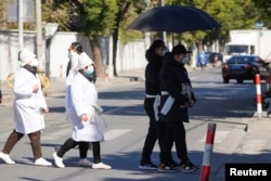 上海一家火葬场外身穿孝服的亲属手捧逝去亲人的遗像。(2022年12月23日)
