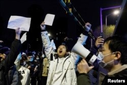 2022年11月28日,在新冠病毒疫情持续扩散之际,北京民众为乌鲁木齐火灾遇难者守夜后,举着白纸抗议中共当局的封控限制。