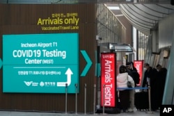资料照 - 韩国卫生部门规定来自中国的旅客到达韩国后必须进行新冠病毒检测。2023年1月1号,韩国仁川国际机场旅客到达处,红牌上写着到达旅客检测。