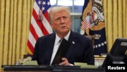 美国总统特朗普在上任首日在白宫椭圆形办公室签署总统行政令。(2025年1月21日)
