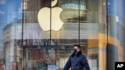 一名男子戴着口罩经过一家因新冠疫情暂时关闭的苹果店。(2020年2月4日)