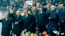 总统国家安全事务顾问亨利-基辛格博士(左三)与北越的黎德寿在巴黎国际会议中心举行的最后一次会议后挥手示意。(美联社照片,1973年1月23日)