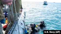 美国海军提供的照片显示美军潜水员在南卡罗莱纳州海岸外打捞被击落的中国间谍气球碎片。(2023年2月7日)