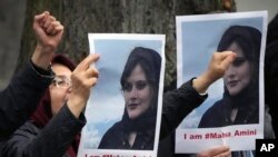 流亡伊朗人举着在伊朗警察局死亡的女子阿米尼的照片在伊朗驻柏林大使馆外抗议。(2022年9月20日)