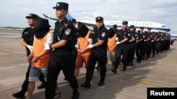 中国警察在长沙黄花国际机场押送一批从柬埔寨遣返的电信诈骗嫌疑人。(2017年7月6日)